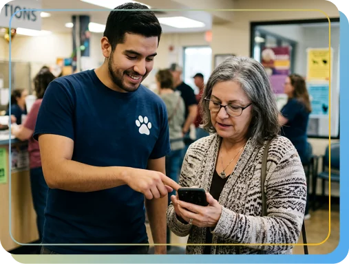 A shelter staff member showing an adopter Shelterpay on a phone