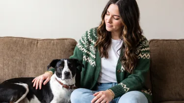 A foster caregiver sitting with her rescue dog